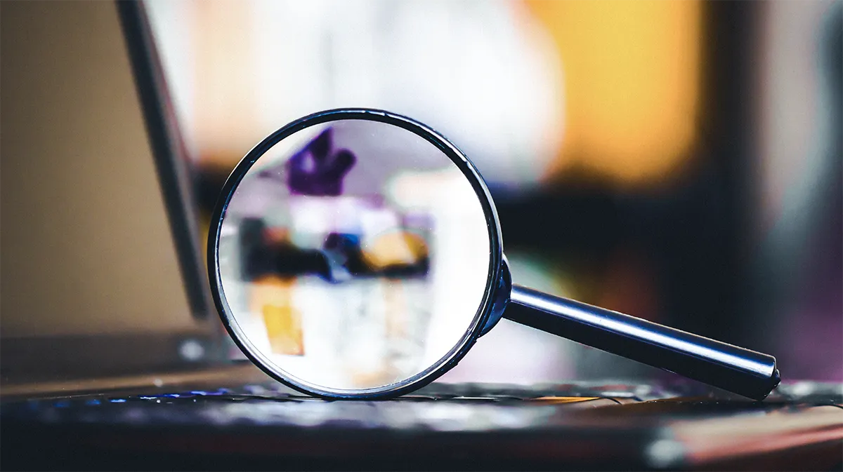 Loupe posée sur un clavier, illustrant un audit approfondi