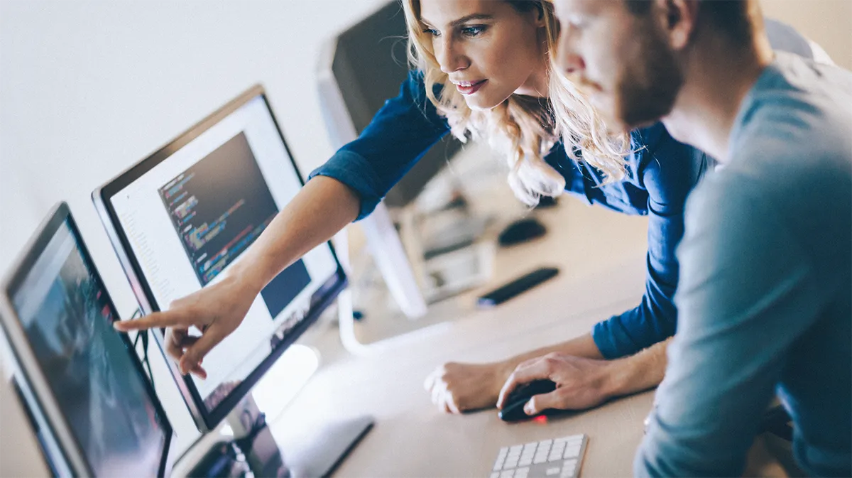Deux collaborateurs analysant un écran, illustrant un accompagnement régulier dans la durée.